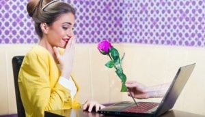 Man offering a rose to a beautiful woman over laptop screen