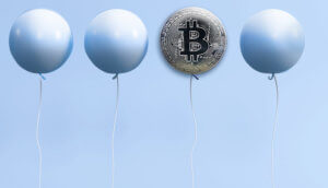 Vier Luftballons, der dritte von links mit einem Bitcoin-Symbol