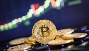 Goldene Bitcoin Münzen vor Charthintergrund
