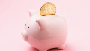 Bitcoin Sparschwein mit Bitcoin Münze im Sparschlitz