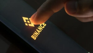 finger drückt auf smartphone mit binance-logo