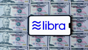 Smartphone mit Libra-Logo auf druckfrischen Dollar-Noten