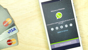 Kredikarten neben Smartphone mit Whatsapp auf dem Display