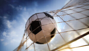 ein fußball, der ins netz fliegt