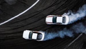 zwei weiße autos von oben, die voll am racen sind