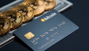 Kreditkarte mit Aufschrift Bitcoin liegt vor mit Bitcoin-Münzen bedecktem Dollarschein