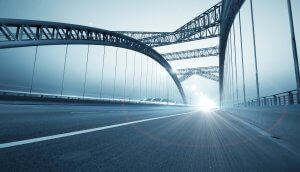 eine moderne brücke, an deren ende ein weißes licht ist
