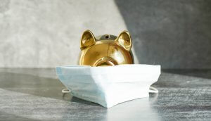 ein goldenes schwein hinter einer corona-atemschutzmaske