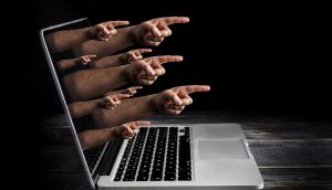 Fotomontage von Zeigefingern, die aus einem Laptop-Display rageb