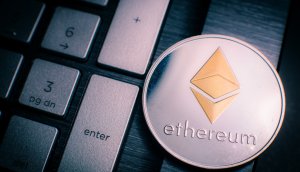 Eine physische Ethereum-Münze neben einer Tastatur.