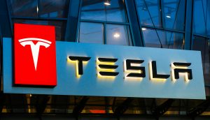 Das Logo von Tesla auf einer gläsernen Gebäudefassade.