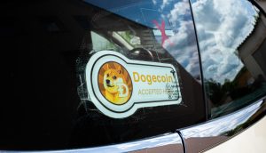 Das Dogecoin-Banner auf einer Autofensterscheibe.