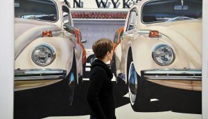 Eine Frau betrachtet am das Kunstwerk "Untitled (4 VW's) (1971)" von Don Eddy