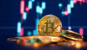 Bitcoin-Münze mit Kursverlauf im Hintergrund.
